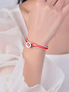 Close up of red and white woven bracelet with silver button clasp on wrist