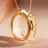 Close up of white jade ring pendant on gold chain