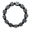 Close-up of a wrist wearing a bracelet with square black lava rock beads and round spacer beads