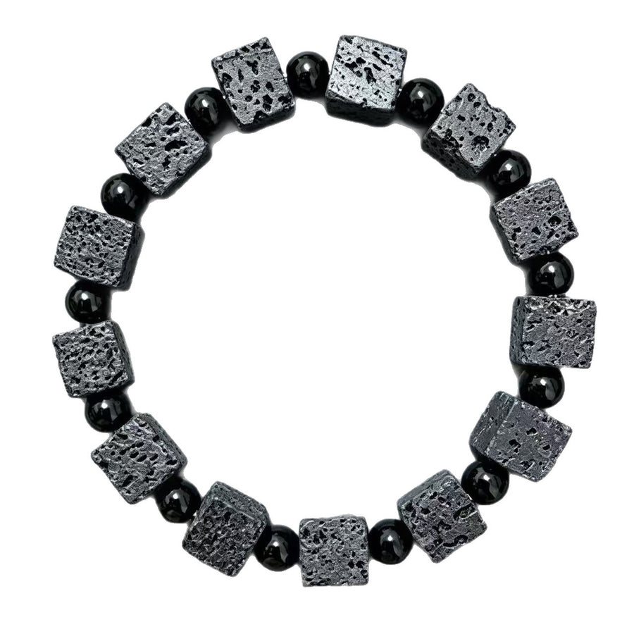 Close-up of a wrist wearing a bracelet with square black lava rock beads and round spacer beads