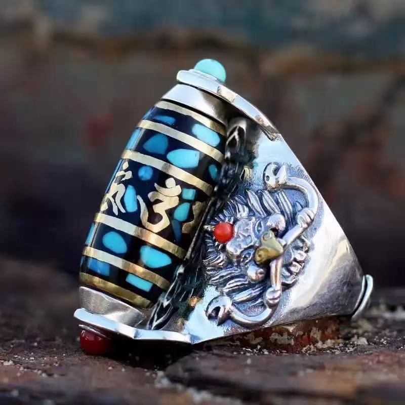 Close up of a copper ring with a blue and gold rotatable barrel and a silver bird design.