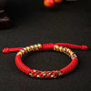 Close up of a red handmade King Kong knot bracelet with a colorful striped center