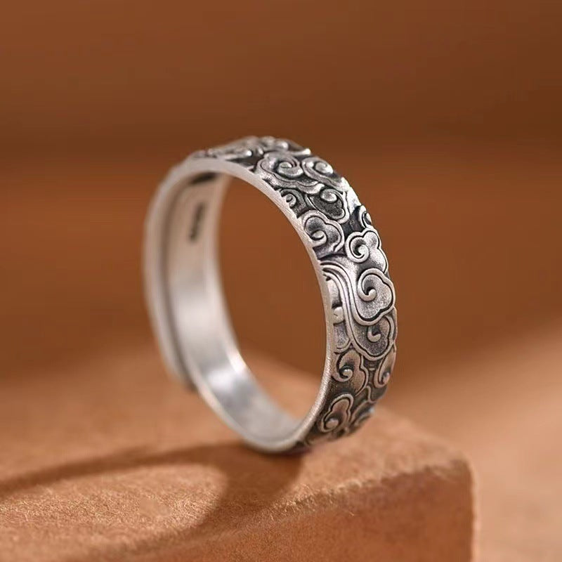 Silver-tone copper ring with engraved cloud patterns on a brown background