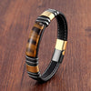 Close-up of a Tiger Eye stone leather bracelet with a gold-tone metal clasp on a wooden surface