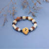 Close up of a stretch bracelet with a yellow ceramic dog charm and brown glass beads