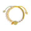 Close up of a light green jade peace buckle bracelet with yellow cord and silver beads