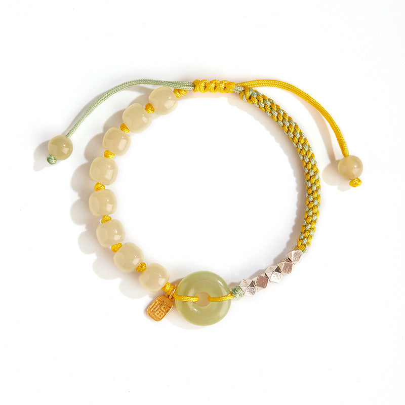 Close up of a light green jade peace buckle bracelet with yellow cord and silver beads