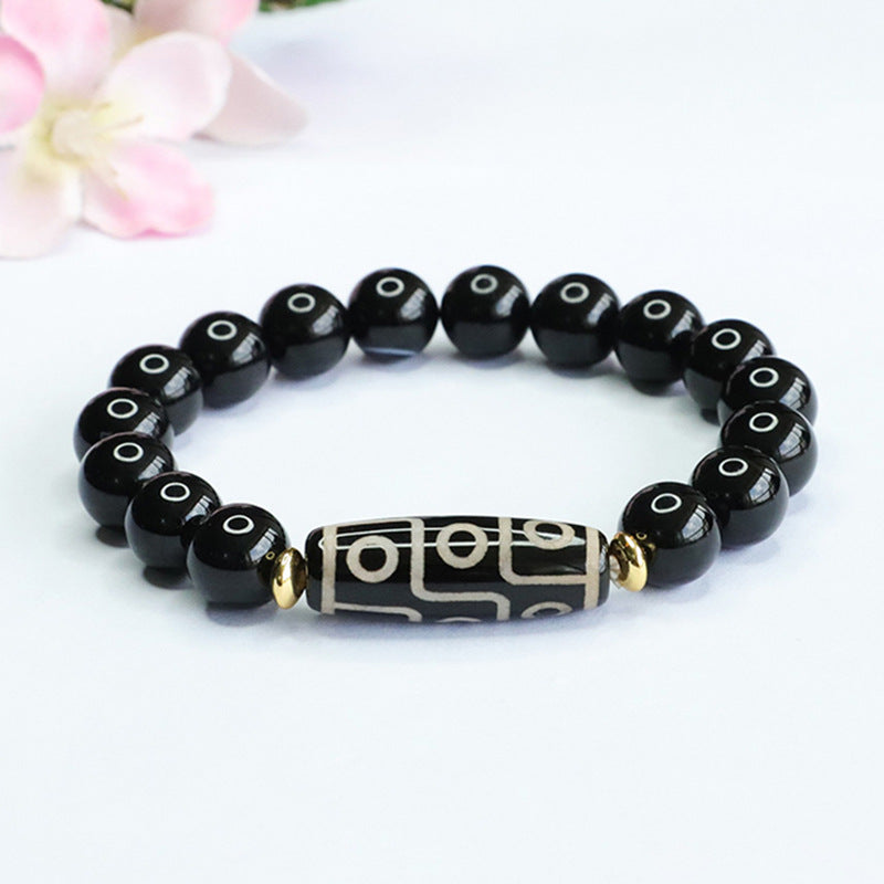 Black agate beaded bracelet with a central nine-eye Dzi bead and gold-tone accents