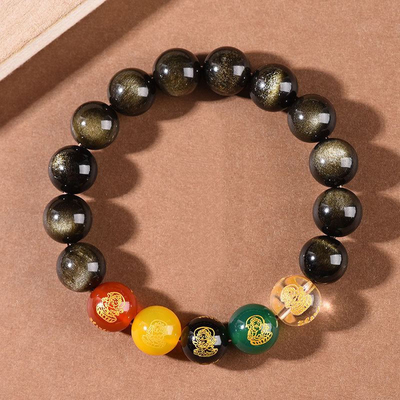 Close up of an obsidian beaded bracelet with five colorful wealth god charms