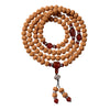 Coiled bodhi seed mala necklace with red accent beads on a wooden surface