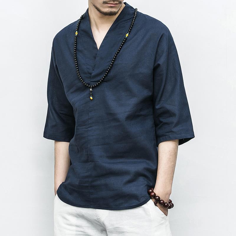Man wearing a dark blue collarless V-neck shirt with three quarter sleeves