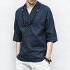 Man wearing a dark blue collarless V-neck shirt with three quarter sleeves