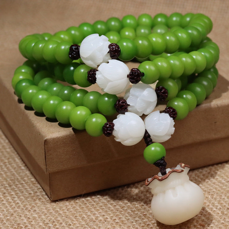 Green 108 bead mala with white lotus beads and a carved money bag charm