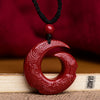Red cinnabar pendant with spiral carvings on a black cord