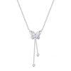 Close up of a silver tone butterfly necklace with white shell wings worn on a collarbone