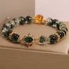 Close up view of a Green Phantom quartz bracelet with gold tone accents and a central green charm