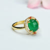 Gold tone ring with an oval green chalcedony stone surrounded by small clear crystals