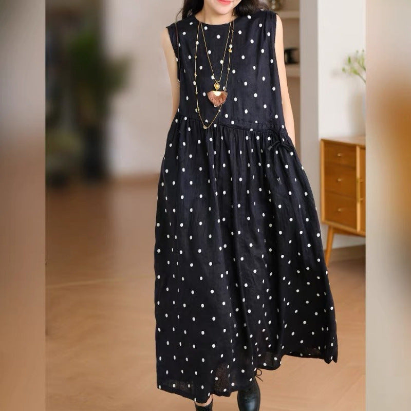 Woman wearing a black sleeveless polka dot cotton linen dress