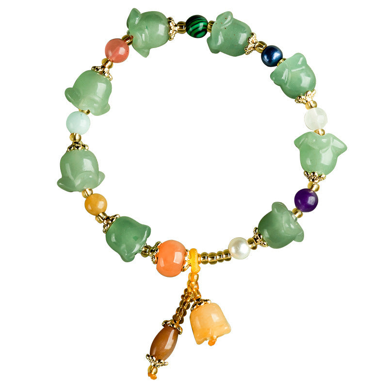 Close up of a green stone bracelet with carved magnolia flowers and colorful spacer beads on a soft background