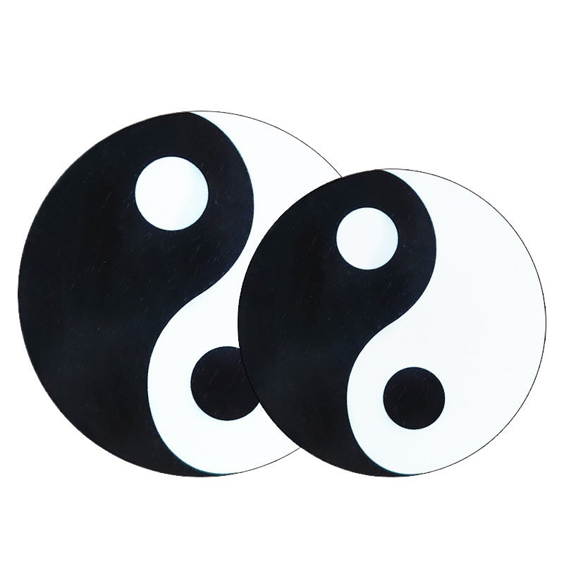 Two round wooden pendants with black and white Yin Yang designs on a white background
