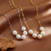 Stainless steel necklace with five faux pearls in a smile shape on a satin background