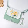Light green cotton linen crossbody bag with yellow flower embroidery on the flap