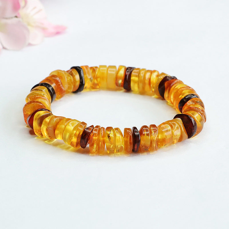 Close up view of an amber bead bracelet with a peace buckle charm