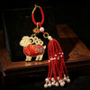Gold-tone sheep keychain with red patterned body and beaded tassel