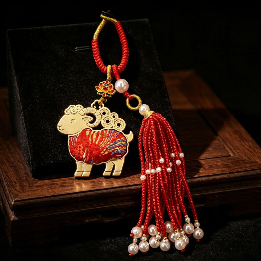 Gold-tone sheep keychain with red patterned body and beaded tassel