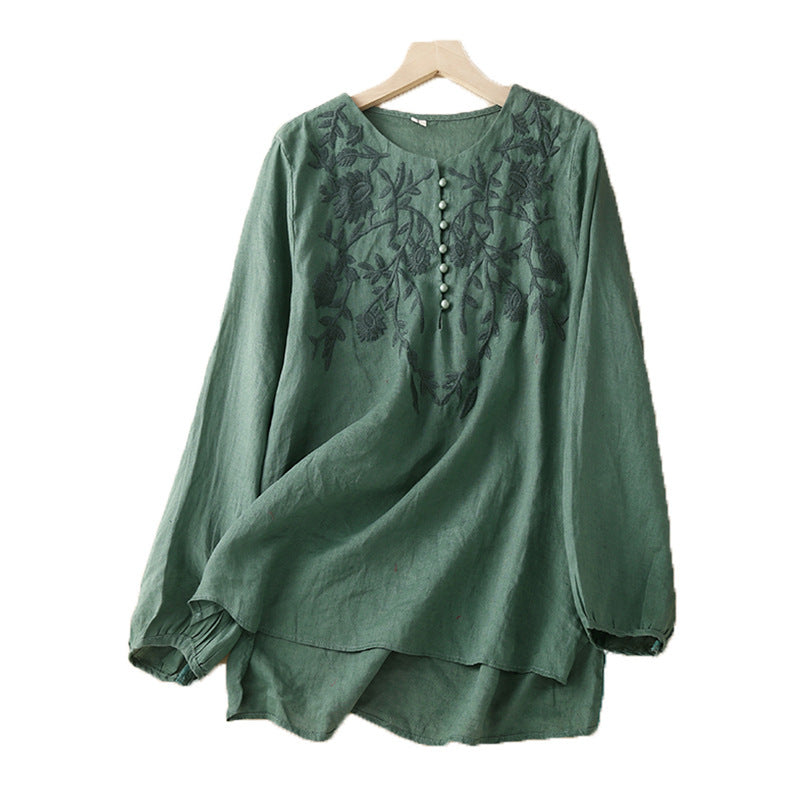Green long sleeve cotton linen top with floral embroidery hanging on a wooden hanger