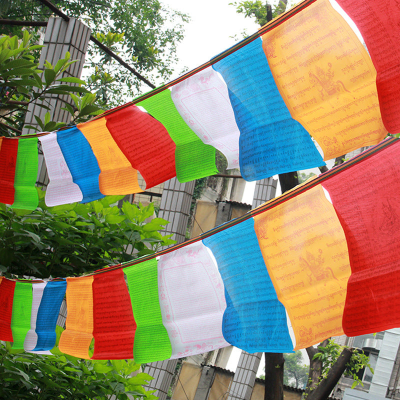 Colorful Tibetan prayer flags strung up outdoors among green trees