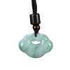 Close up of a pale green cloud shaped jade pendant on a black cord