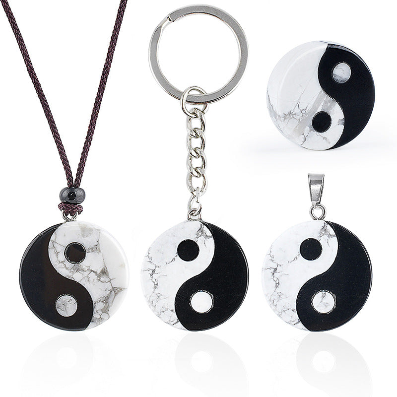 Round Yin Yang pendant with black and white stone pattern on a cord