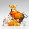 Amber and multi-colored Liuli glass figurine of an ox on a clear base