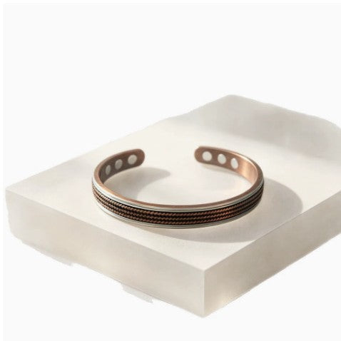 Rustic copper cuff bracelet with twisted texture on white display block