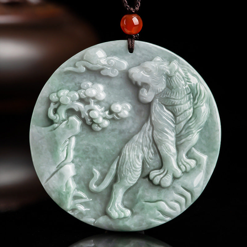 Round light green jade pendant carved with a roaring tiger and pine tree