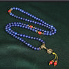 Close up of blue lapis lazuli and red turquoise beads on a handmade mala bracelet