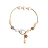 Gold-tone bracelet with white baroque pearls and a pink stone charm