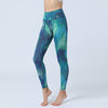 A woman wearing high waist yoga leggings with a blue and green abstract leaf print pattern