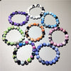 Several colorful galaxy agate bracelets arranged on a white surface