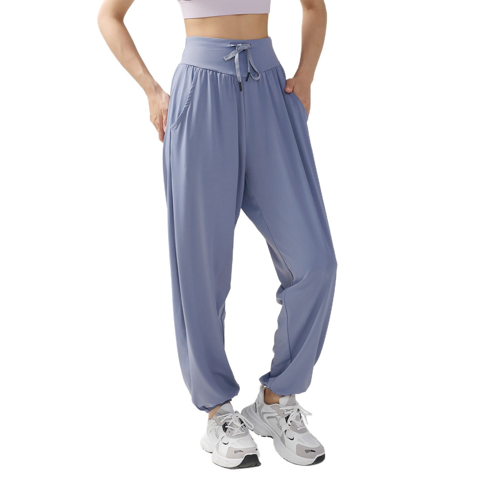 Model wearing light blue loose harem yoga pants with hands in pockets