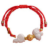 Close up of a red string bracelet with white jade charms and a gold bead