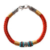 Close up of red braided cord bracelet with silver six true words charm