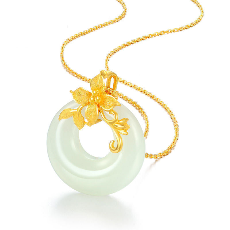 Close up of a pale green peace buckle pendant with a gold camellia on a chain