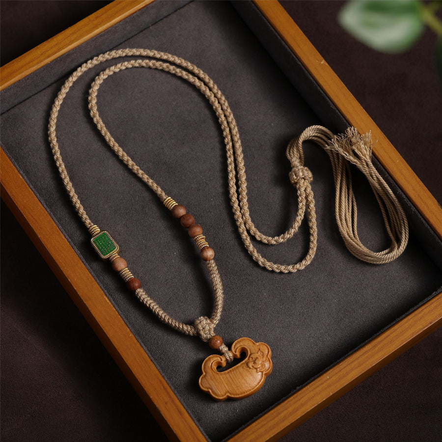 Khaki cotton cord necklace with a carved wooden peace lock pendant