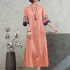 Woman wearing a peach-colored embroidered midi dress with half sleeves