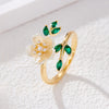 Gold tone open ring with white flower and green leaves
