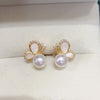 Close up of gold butterfly stud earrings with white pearls