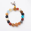 Close up view of an eighteen seed bodhi bracelet with mixed wood and stone beads resting on a book page