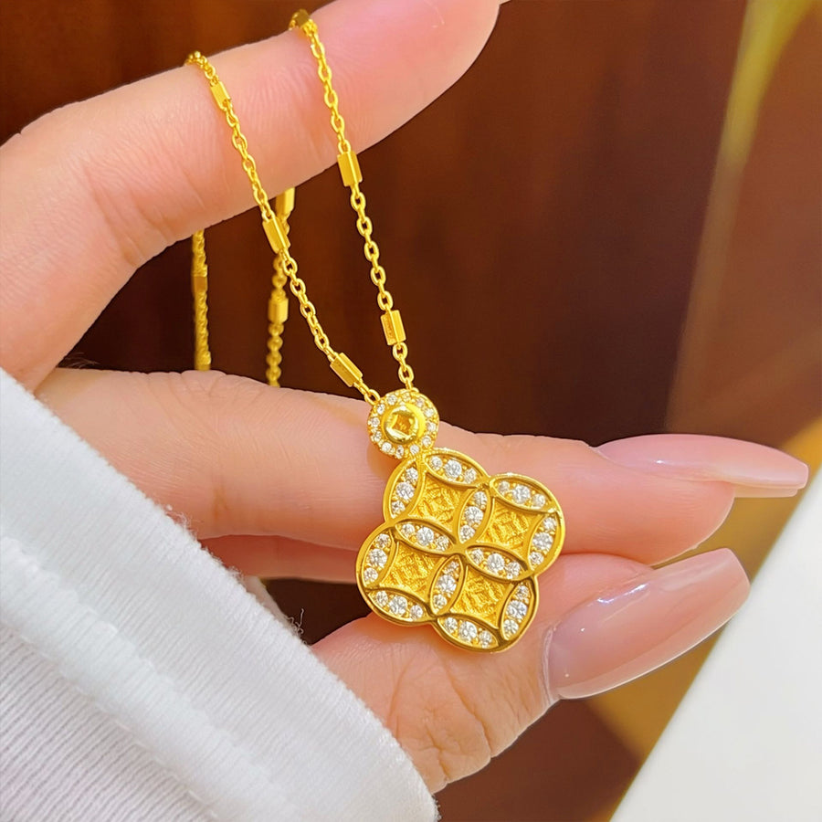 Gold-tone pendant with four leaf clover coin design held in hand